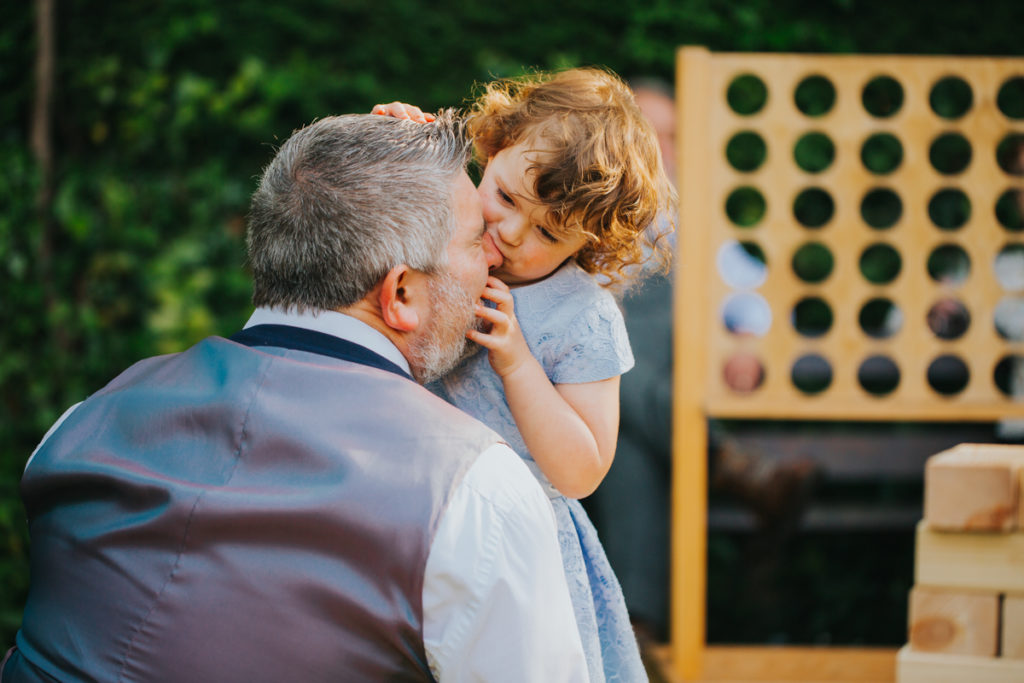 kid at wedding biting dad's nose