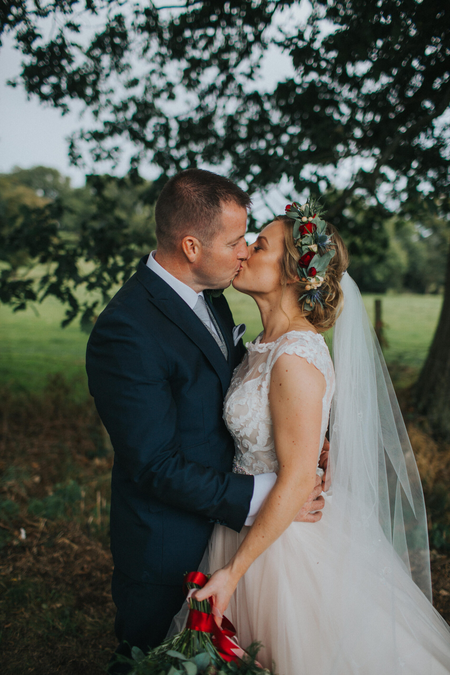 newlyweds kissing in a field