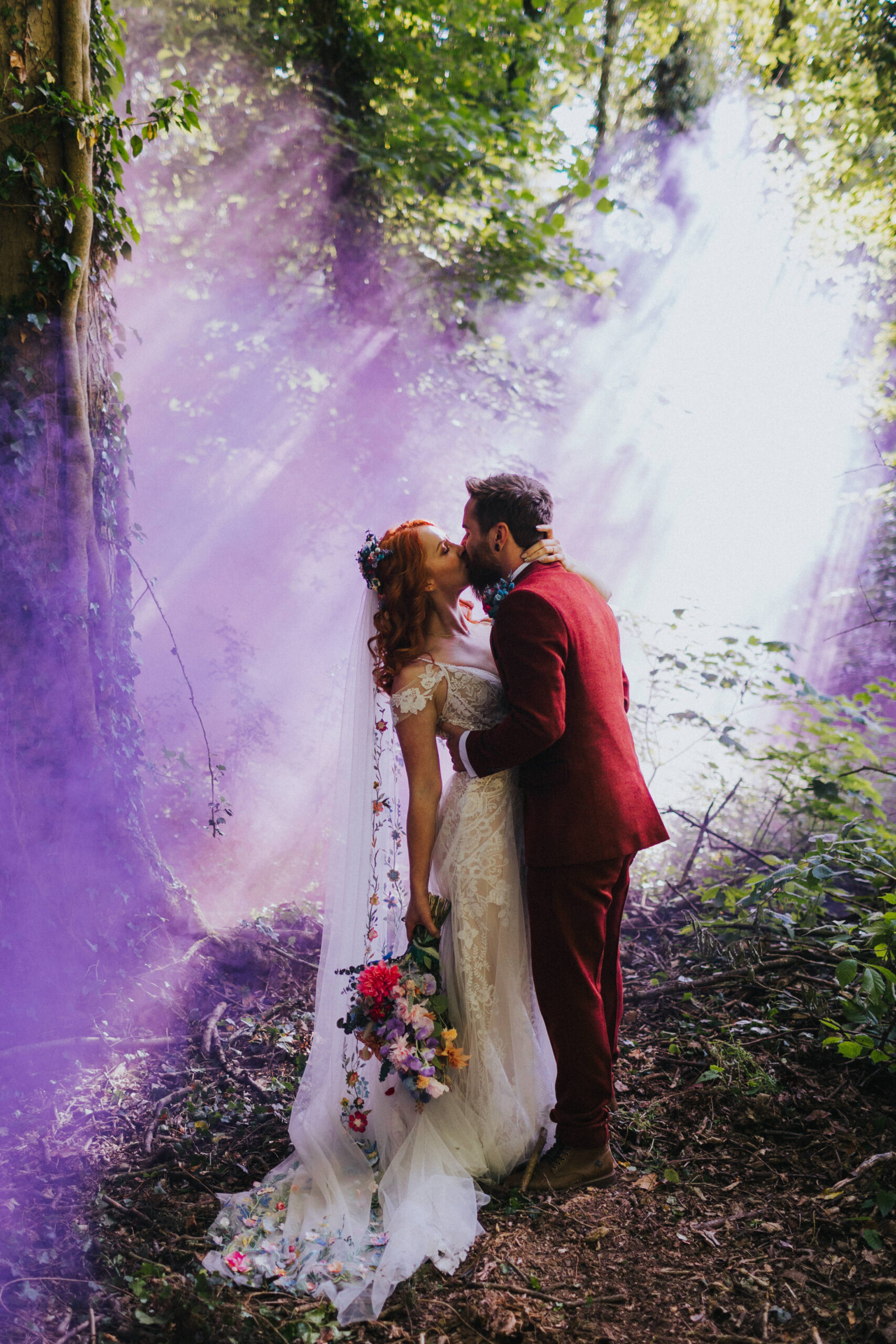 Bride and groom at Wrekin Forest Events with a purple smoke bomb and sunlight beams