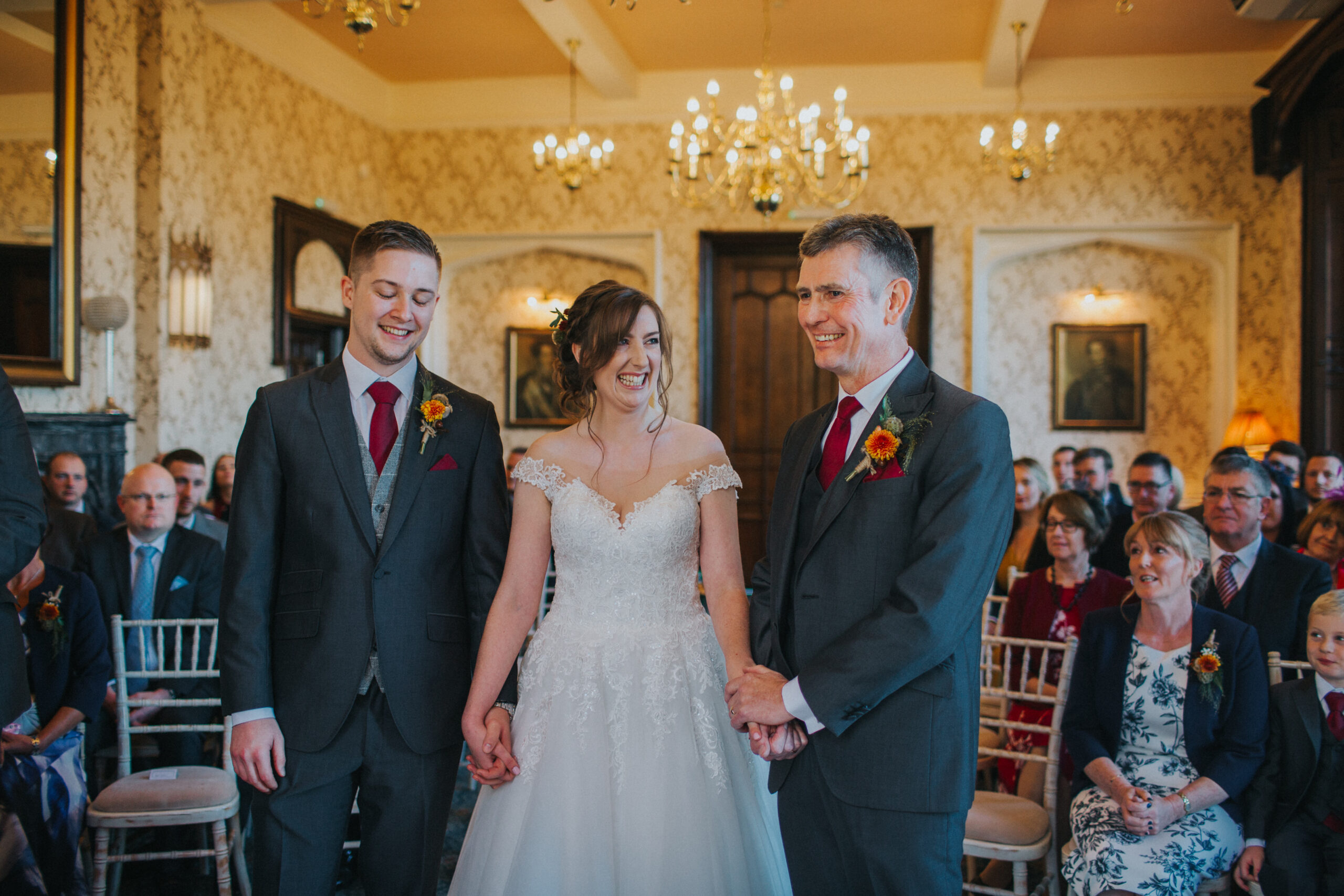 Bride, dad and groom at the front of the aisle, smiling