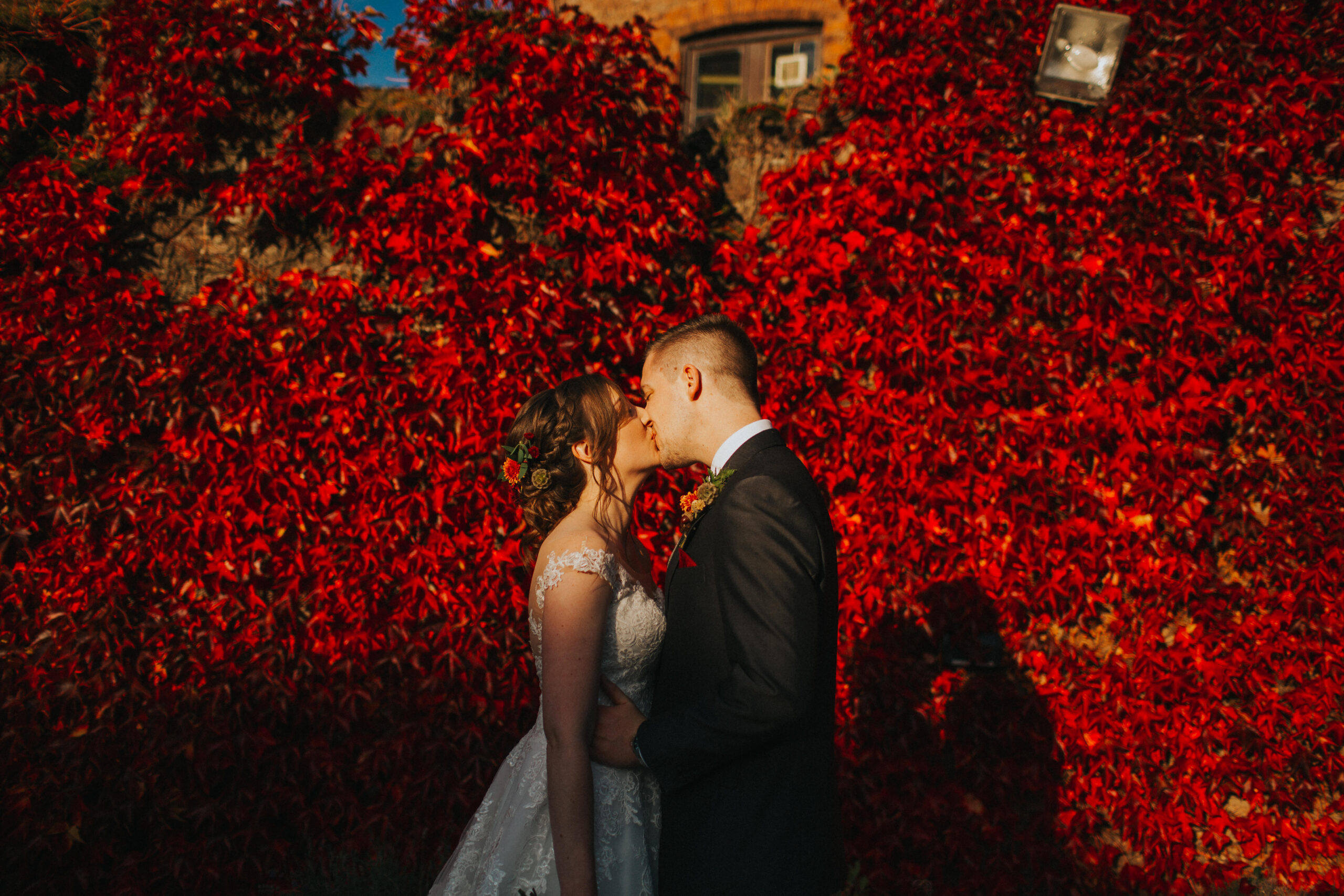 bride and groom kissing in harsh autumnal light