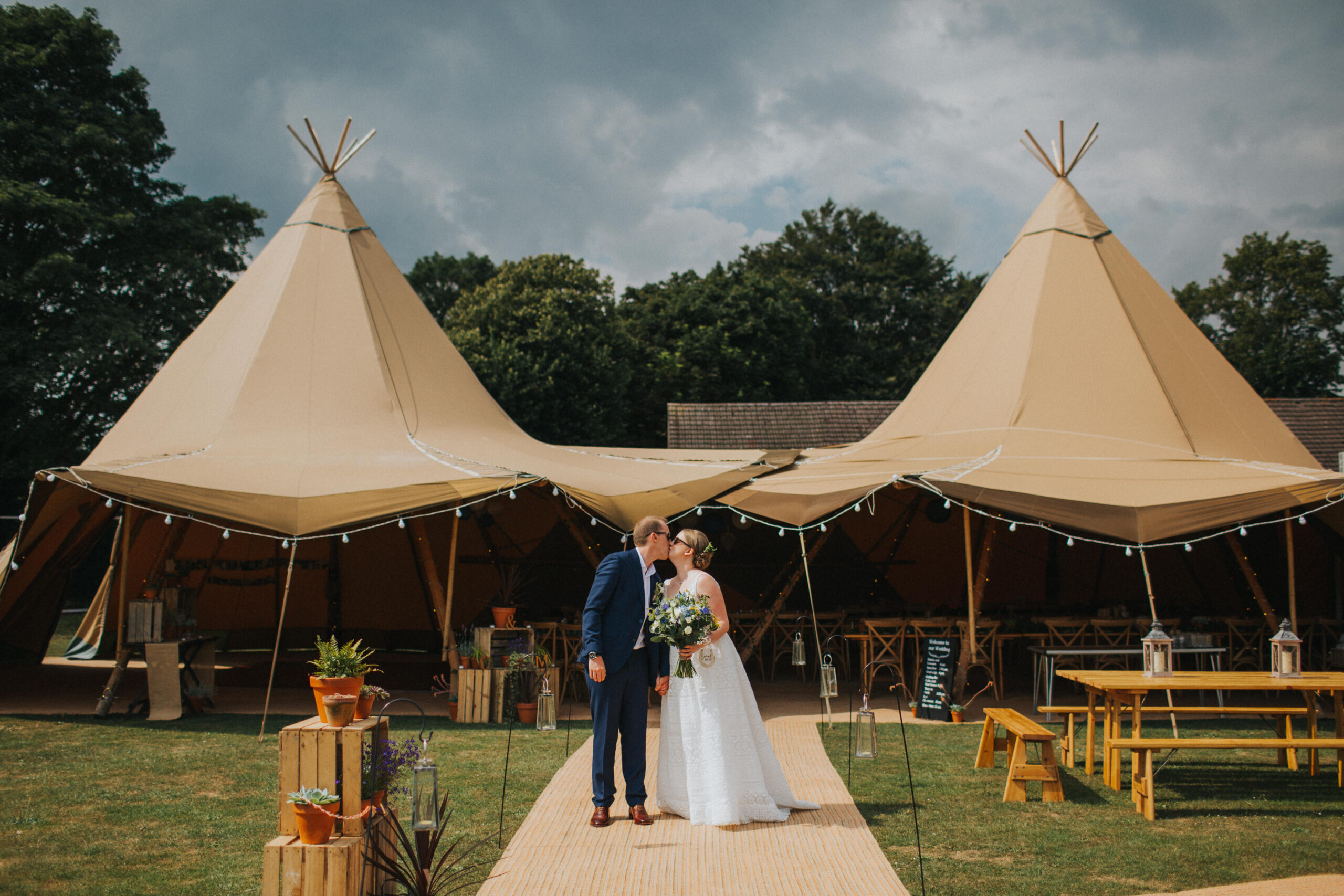 bride and groom kissing outside tipi