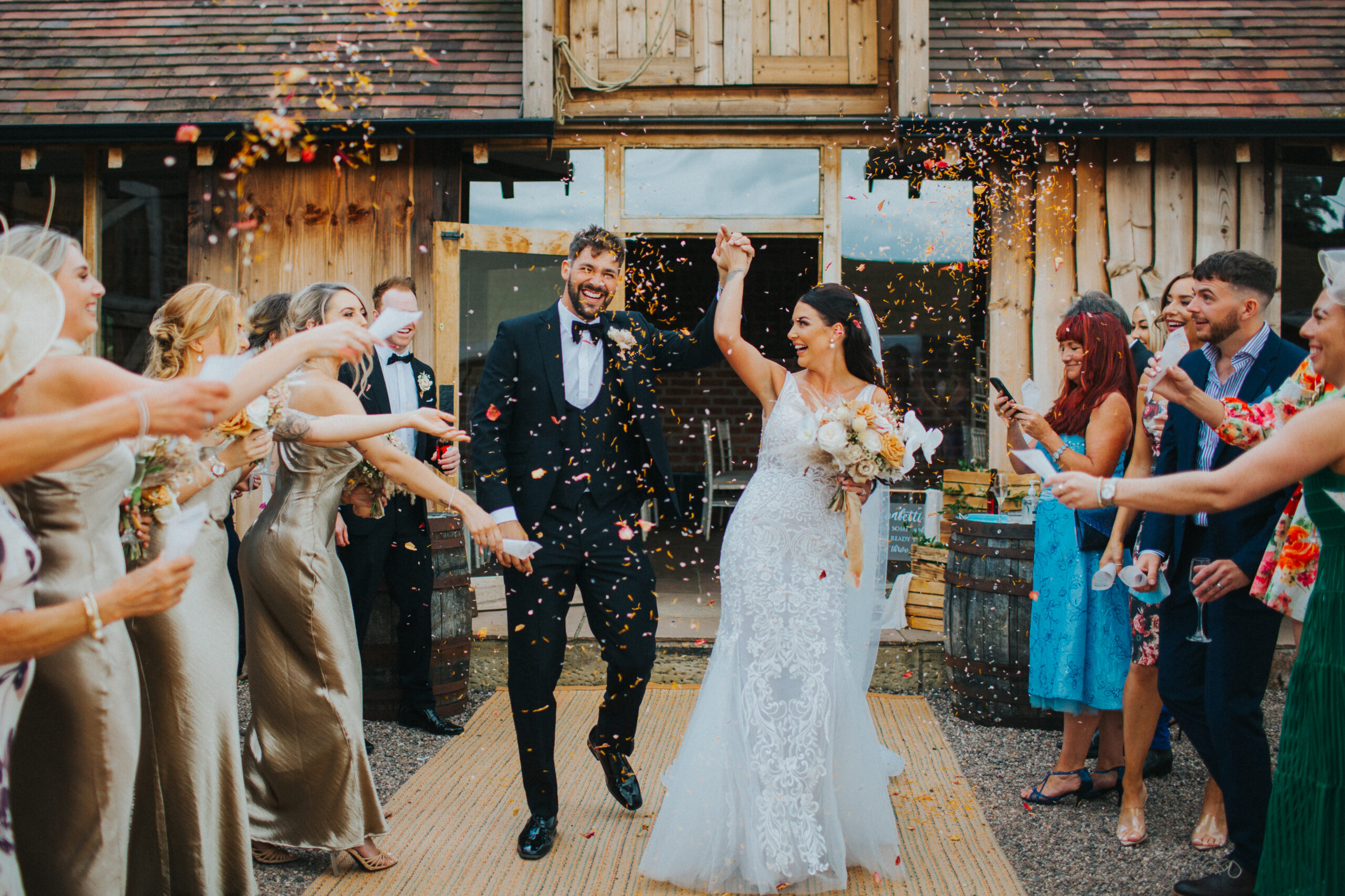 Bride and groom smiling amidst a sea of confetti