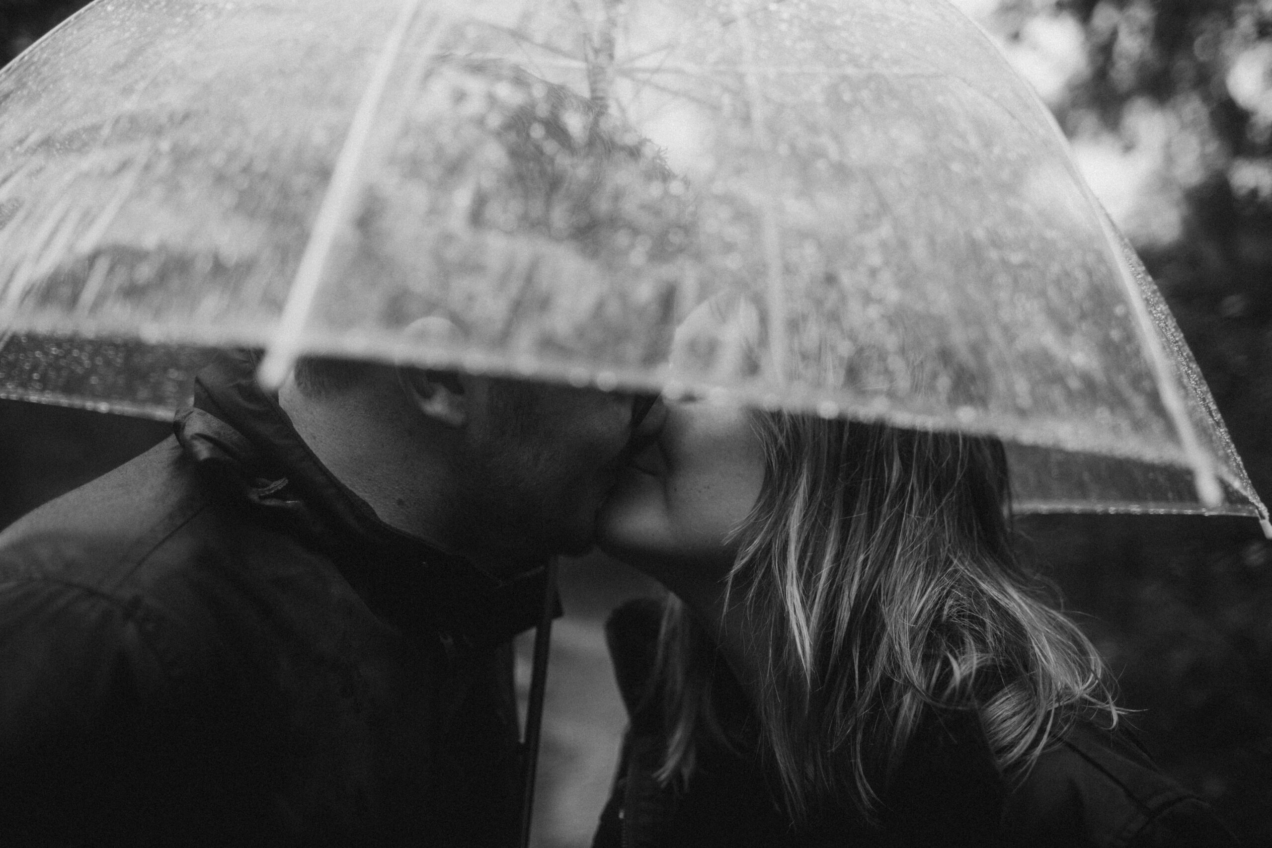 couple under an umbrella during an engagement shoot