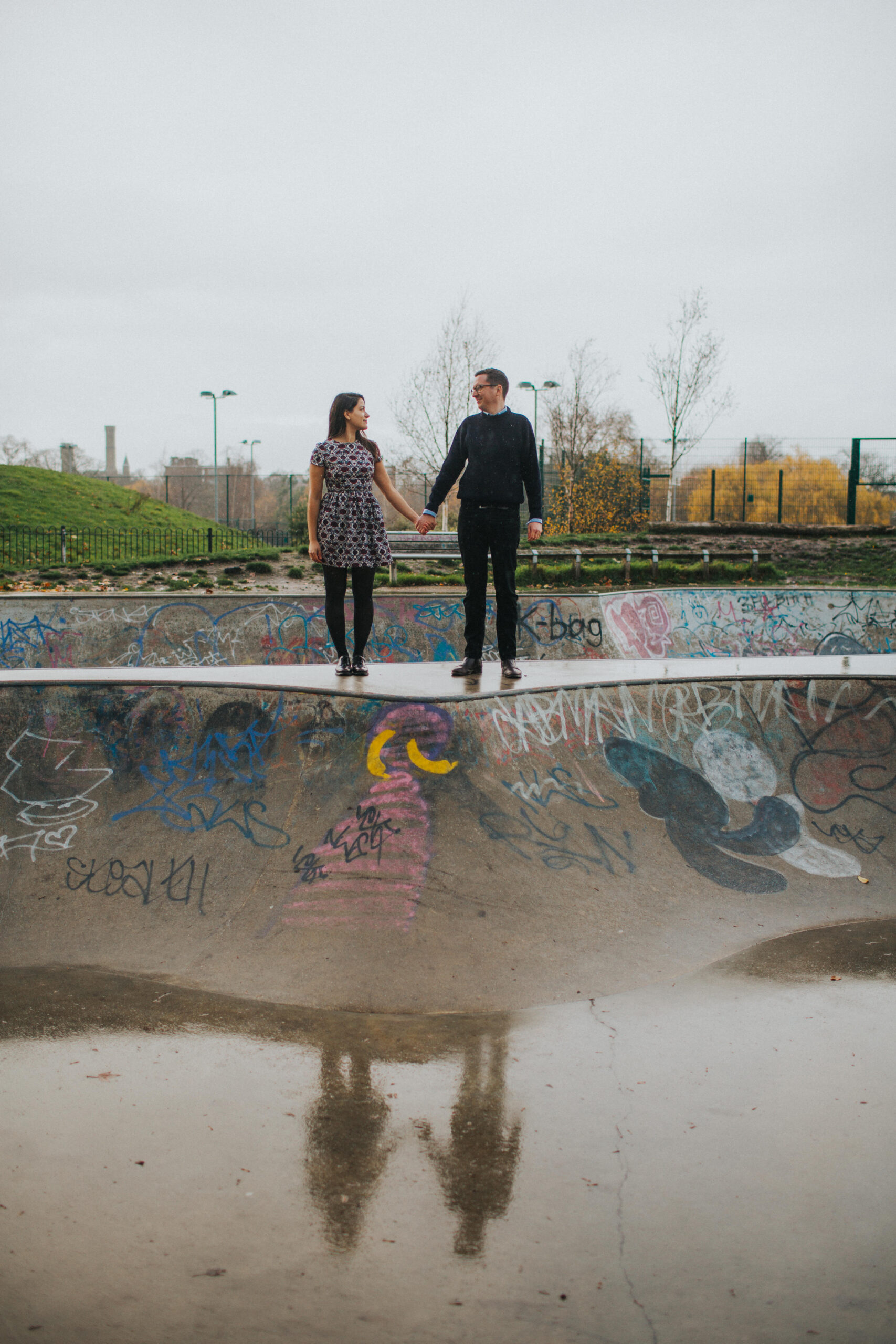 Elegant couple framed by the iconic bridge at Clissold Park