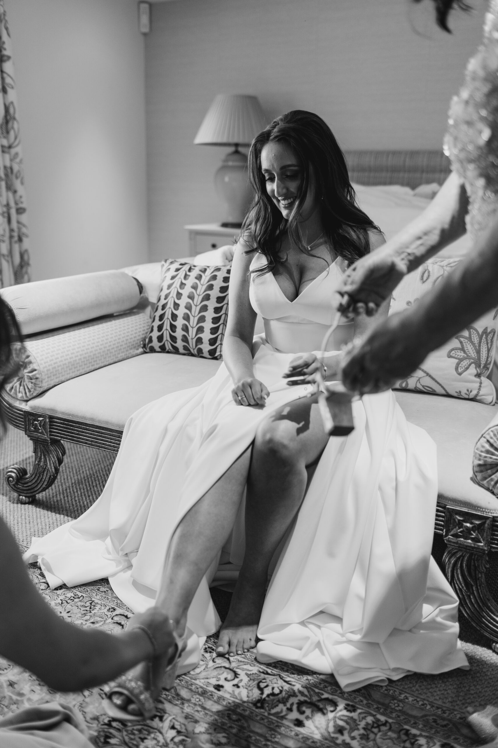 bride being helped in to wedding shoes