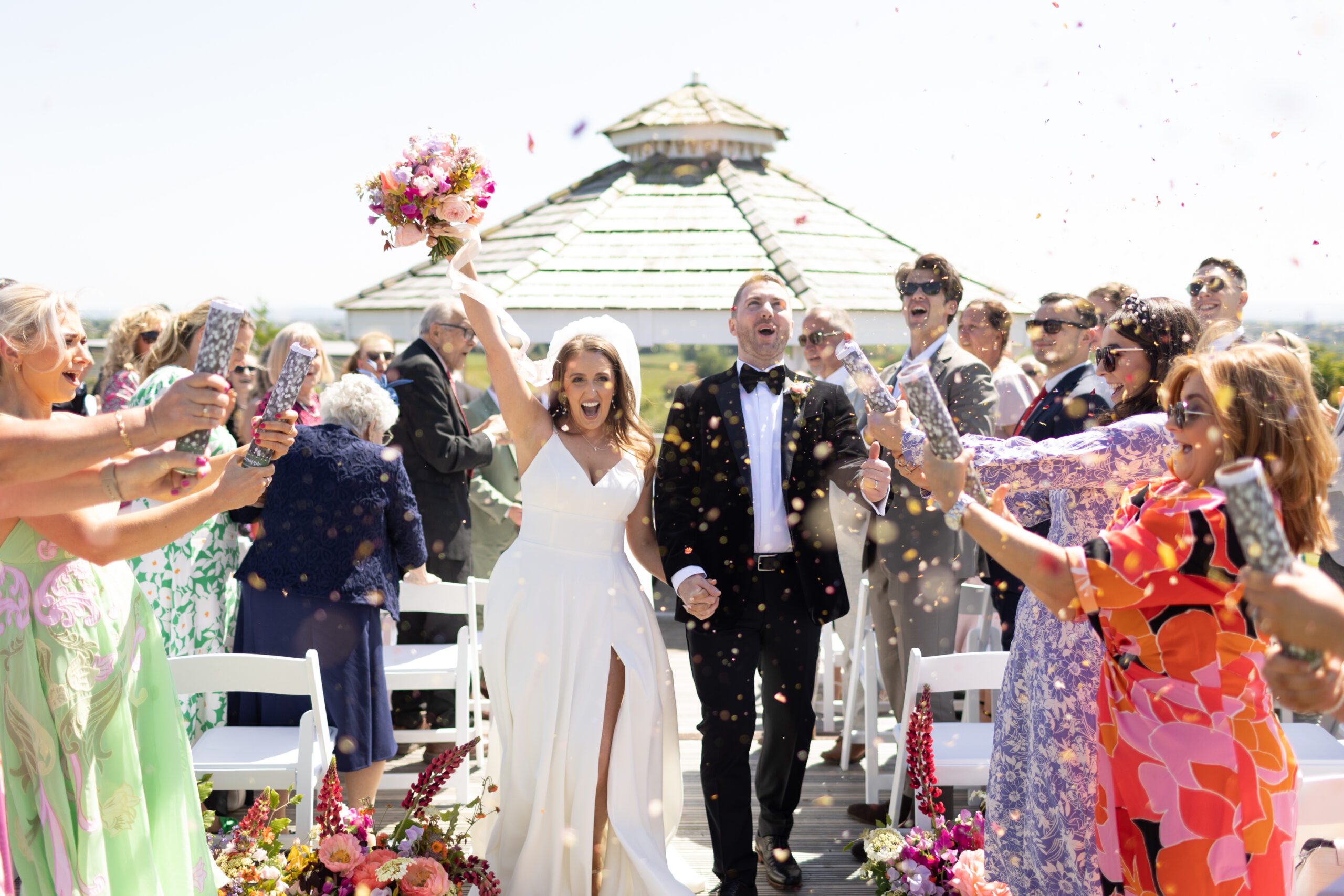 Bride and groom basking in the confetti-filled joy