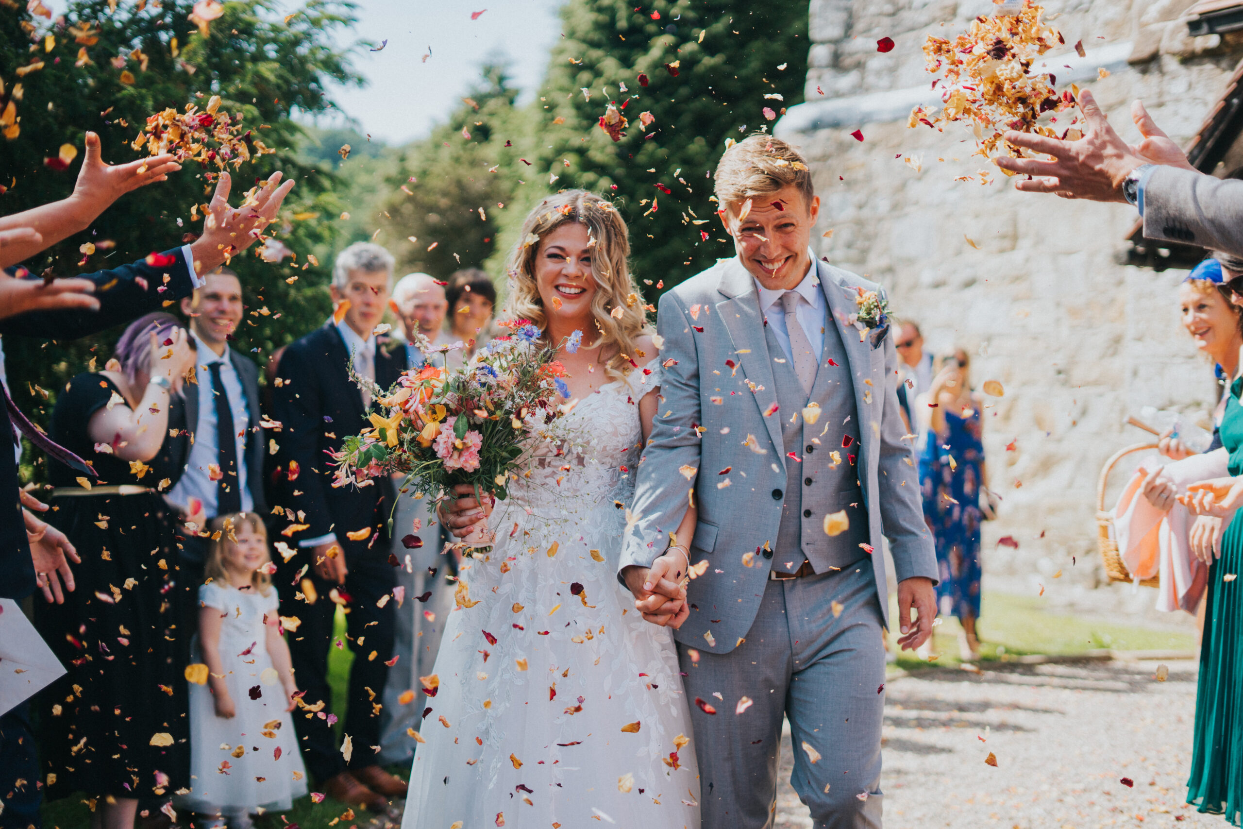 Bride and groom engulfed in a shower of confetti