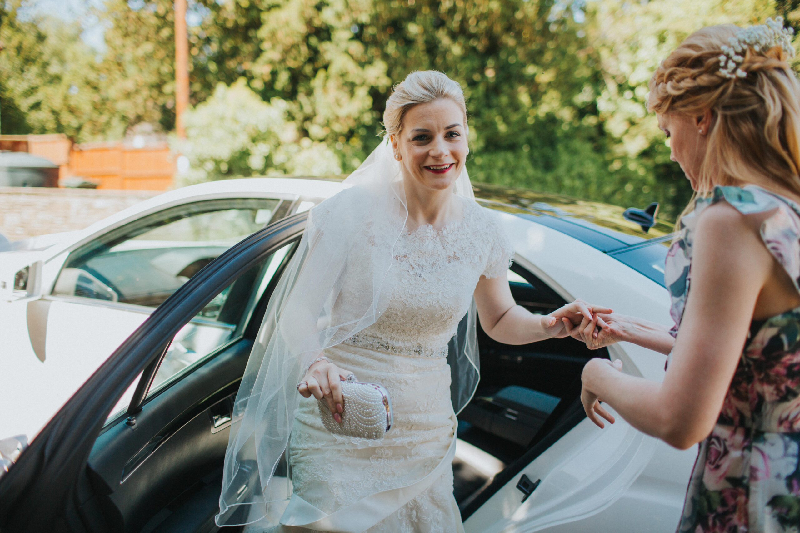 bride exiting bridal car outside church