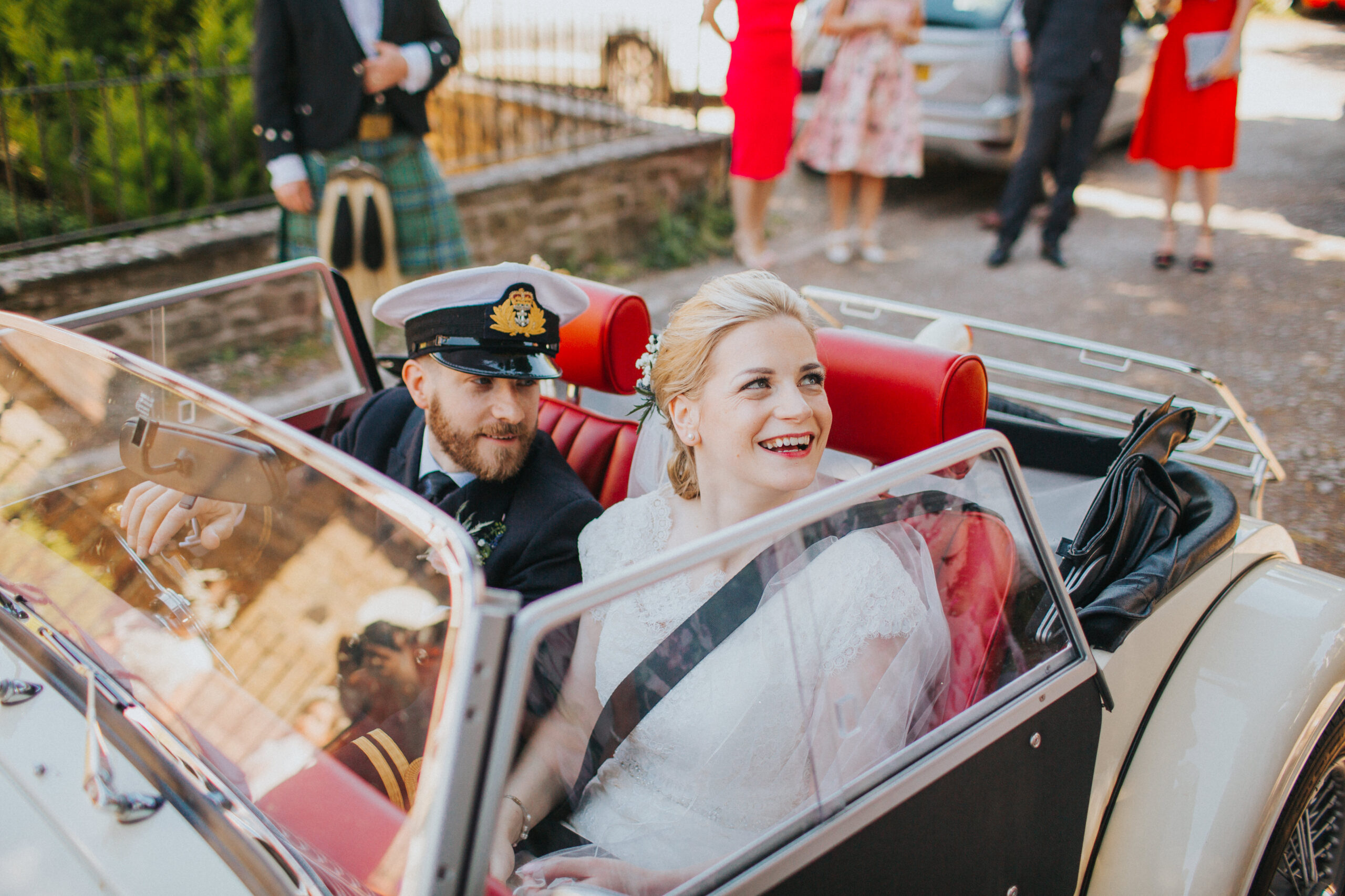 Bride and Groom driving away in a classic Morgan car